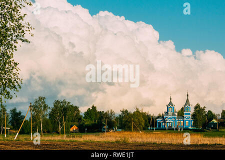 Orthodoxe Kirche in einem Dorf vor dem Hintergrund von Cumuluswolken. Krasnyy Partizan, dobrush Bezirk, Region Gomel, Belarus. Stockfoto