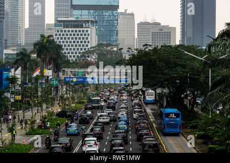 Jakarta, Indonesien - 16. November 2018: Stau entlang der Sudirman Road im Herzen von Jakartas Geschäftsviertel an einem regnerischen Tag mit Transjakarta Stockfoto