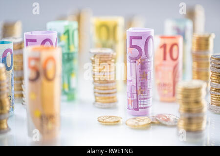 Gerollt Euro-Banknoten und -münzen Türme in anderen Positionen gestapelt Stockfoto