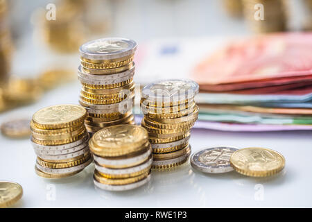 Euro-banknoten und -Münzen togetger auf weißem Tabelle - close-up Stockfoto