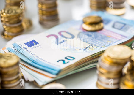 Euro-banknoten und -Münzen togetger auf weißem Tabelle - close-up Stockfoto