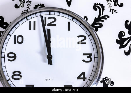 Große silberne Uhr an der Wand, der an fast Mitternacht Stockfoto