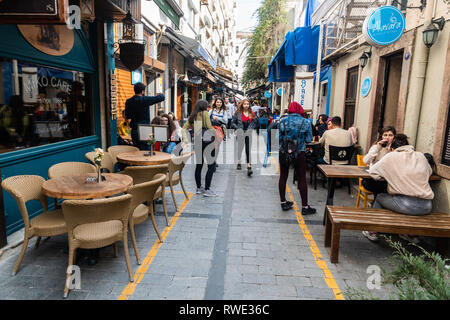 Izmir, Türkei - März 2, 2019. Schmale cafe gesäumten Straße im Viertel Alsancak Izmir, mit Gewerbe und Menschen. Stockfoto