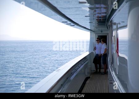 In der breiten Ansicht von 2 Superyacht Crew in Uniform auf Deck reden, Meer Hintergrund Stockfoto