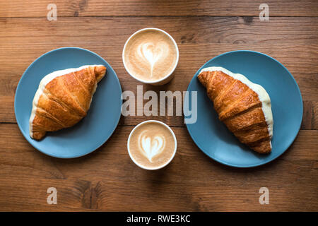 Cappuccino und Croissants auf Holz- Hintergrund. Stockfoto