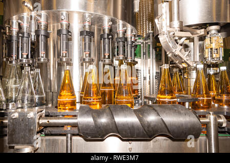 Füllen Glasflaschen mit Saft. Abfüllung von Getränken. Abfüllanlage Stockfoto