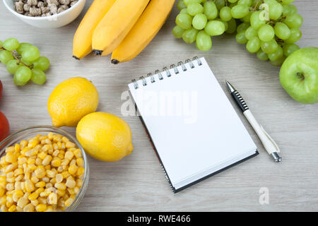 Notebook mit einem Diätplan mit frischem Gemüse und Früchten auf den Tisch Nahaufnahme Stockfoto
