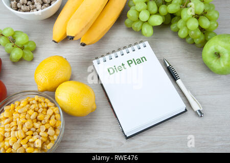 Notebook mit einem Diätplan mit frischem Gemüse und Früchten auf den Tisch Nahaufnahme Stockfoto
