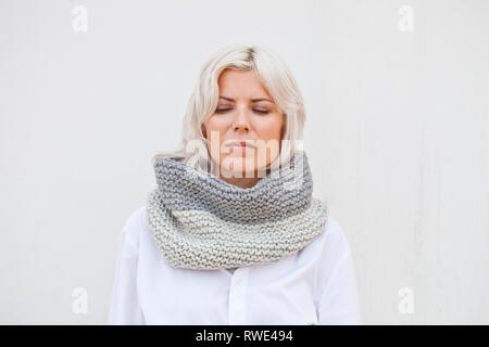 Hübsche junge Frau in warmen grauer Wolle gestrickt snood Schal. Stockfoto