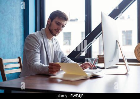 Mann bei der Arbeit am Computer im modernen Büro. Stockfoto