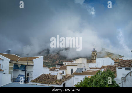 Die frühen Morgenwolken sind unten über den Bergen und der kleinen Stadt Carcabuey in den Sierras Subbeticas, Andalusien, Spanien Stockfoto