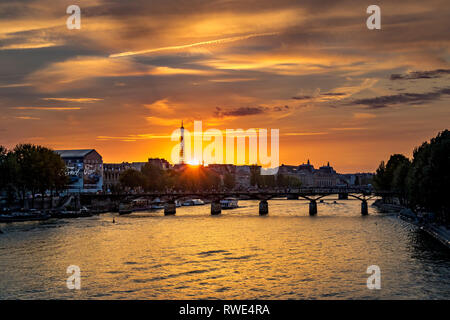 Paris und die seine, die bei Sonnenuntergang unter der Pont des Art fließt, mit dem Eiffelturm in der Ferne, Paris, Frankreich Stockfoto