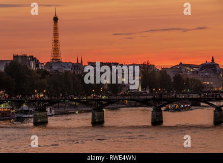 Paris und die seine, die bei Sonnenuntergang unter der Pont des Art fließt, mit dem Eiffelturm in der Ferne, Paris, Frankreich Stockfoto