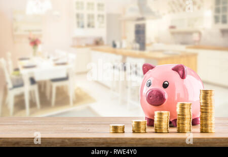 Rosa Sparschwein Münzen und moderne Küche Interieur im Hintergrund. Bank oder Versicherung Konzept Stockfoto