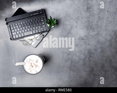 Flach, Ansicht von oben Bürotisch Schreibtisch. Arbeitsbereich mit leeren clip Platine, Tastatur, grünen Kaktus und Kaffee Tasse auf grauem Hintergrund, kopieren Raum Stockfoto