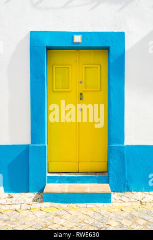 Gelbe Tür im traditionellen portugiesischen Haus auf Blau und Weiß, Tavira, Algarve lackiert Stockfoto