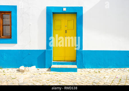 Gelbe Tür im traditionellen portugiesischen Haus auf Blau und Weiß, Tavira, Algarve lackiert Stockfoto