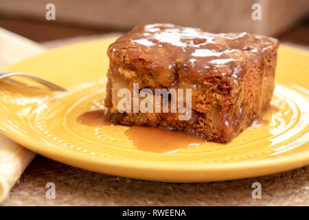 Stück Apple Pecan Cake mit Karamell bereifen serviert auf gelbem Teller, Gabel und Servietten Stockfoto