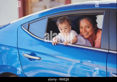 Lächelnde Frau mit baby girl Blick aus dem Auto Fenster Stockfoto