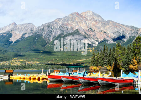 Kleine Boote und Tretboote am Dock am Pyramid Lake bei Pyramid Lake Resort in Jasper, Alberta. Pyramide Berg ist im Hintergrund Stockfoto