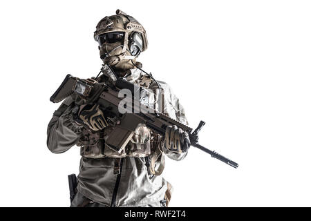 Desatured studio geschossen von einer Armee Soldat in Schutzmaßnahmen gegen einheitliche Holding Assault Rifle. Stockfoto