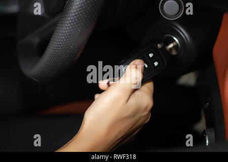 Frauenhand halten Sie die Taste zum Starten der Auto, selektiven Fokus auf Seite Stockfoto