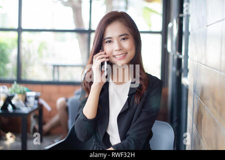 Geschäftsfrau asiatische mit Telefon für Decke und Textnachrichten auf Ihr Mobiltelefon Stockfoto