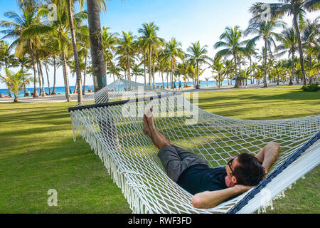 Touristische Mann Entspannen in großen Seilhängematte, Panglao - Bohol, Philippinen Stockfoto