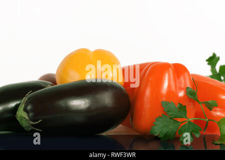 Paprika, Auberginen und Zweige Petersilie auf einem weißen Hintergrund. Stockfoto