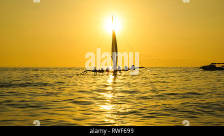 Segelboot mit Sitzen Touristen auf goldenen Sonnenuntergang Meer - Insel Boracay, Panay - Philippinen Stockfoto
