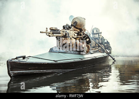 Special forces Operator bewaffnet mit Maschinengewehr, paddeln Armee Kajak durch Fluss Nebel. Stockfoto