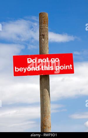 Ein Schild "Nicht über diesen Punkt hinaus" gegen einen blauen Himmel gesehen. Stockfoto