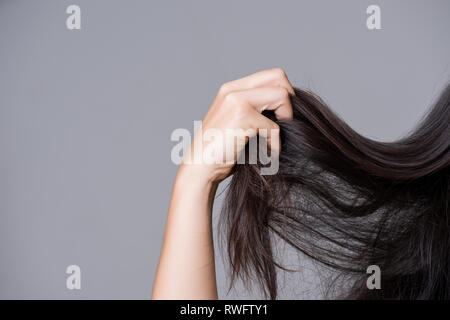 Gesundes Konzept. Frau Hand beschädigt lange Haare. Stockfoto