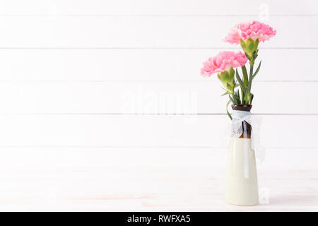 Valentines Tag und liebe Konzept. Rosa Nelke Blume in der Vase auf weißem Holz- Hintergrund. Stockfoto