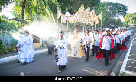 Gekleidete Priester Rauchopfer während Christus König Prozession - Miagao, Iloilo - Philippinen Stockfoto