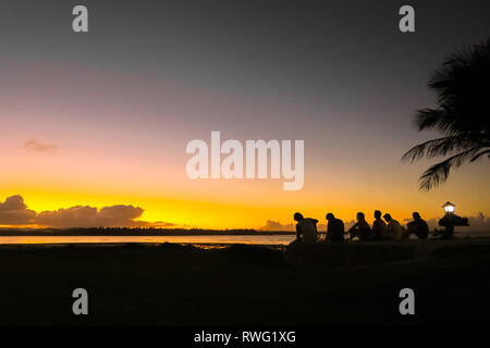 Freund Gruppe genießen Sie einen wunderschönen Orange Insel Sonnenuntergang, Sitzen auf den Strand - Wolke 9, Siargao - Philippinen Stockfoto