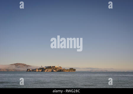 Alcatraz angesehen vom Ufer aus mit Nebel über dem Wasser im Hintergrund Stockfoto