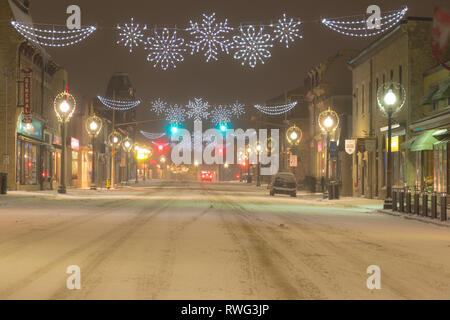 Hauptstraße in Fergus auf einer verschneiten Nacht mit Weihnachtsbeleuchtung. Fergus, Ontario, Kanada Stockfoto