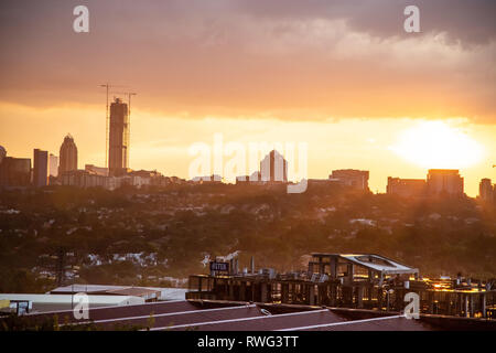 Johannesburg, Südafrika, 18. Januar - 2019: Blick Richtung Stadt über die Dächer mit Sonnenuntergang und Regen Wolken Stockfoto