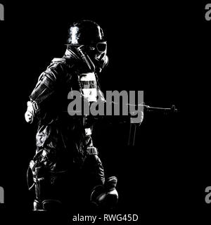 Futuristische NS-Soldat mit Maschinenpistole auf dunklem Hintergrund. Stockfoto