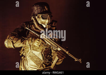 Futuristische NS-Soldat mit Maschinenpistole auf dunklem Hintergrund. Stockfoto