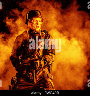 Hässliche Fratze des futuristischen NS-Soldaten verbrannt trägt einen Stahlhelm. Stockfoto