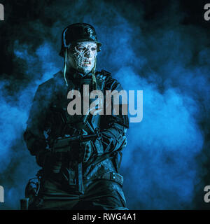 Hässliche Fratze des futuristischen NS-Soldaten verbrannt trägt einen Stahlhelm. Stockfoto