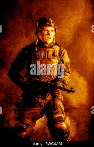 Hässliche Fratze des futuristischen NS-Soldaten verbrannt trägt einen Stahlhelm. Stockfoto