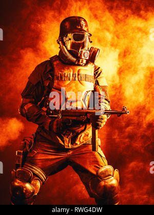 Futuristische NS-Soldat trägt eine Gasmaske und eine Maschinenpistole in Feuer und Rauch. Stockfoto