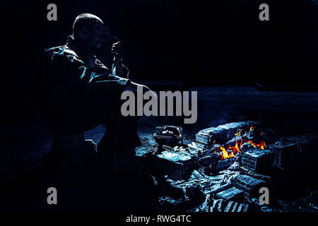 Special forces Soldaten das Rauchen einer Zigarette durch das Feuer in einem zerstörten Gebäude. Stockfoto