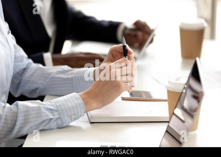 Closeup diverse Geschäftsleute sitzen am Tisch zu hören Lautsprecher Stockfoto