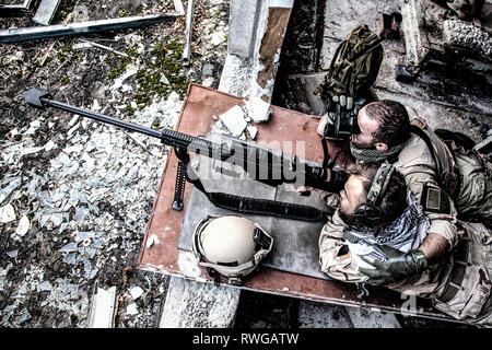 Us Navy SEALS sniper Team feuern ein Scharfschützengewehr aus einem verlassenen Gebäude. Stockfoto