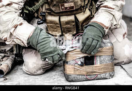 Armee Soldat mit einer Zange Drähte auf einer improvisierten explosiven Gerät zu schneiden. Stockfoto