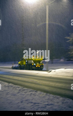 Schneepflug fahren auf der Straße während eines Schneesturms in der Nacht in Toronto Vororte Stockfoto